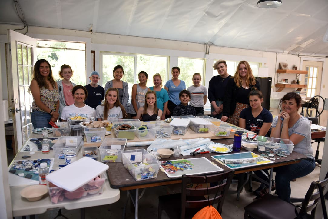 group of people standing around table